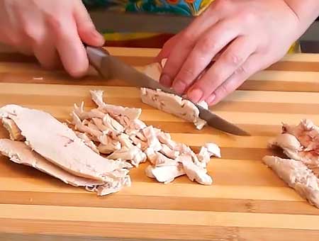 Мясо курицы складываем стопкой и режем на полоски