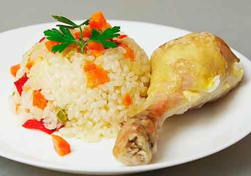 куриная голень с рисом на тарелке 